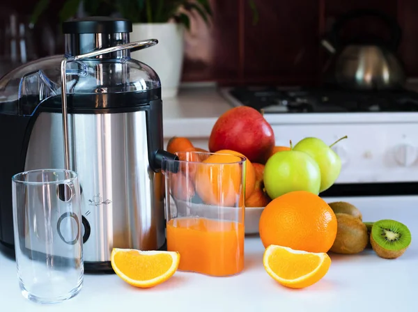 Taze sıkılmış meyve suyu ve mutfaktaki masada olgun meyveler. Evde lezzetli ve sağlıklı meyve suları var. Yakın plan. Seçici odak.