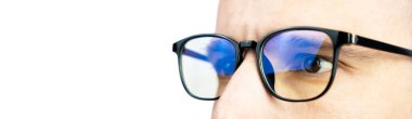 The look of a young man with glasses looking at the monitor isolated on white background. Computer games, work online. Banner. Close-up. Copy space. Selective focus.