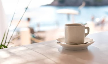 Cup of espresso in a summer cafe on the beach. Relaxation by the sea. Close-up. Place for text. Selective focus.
