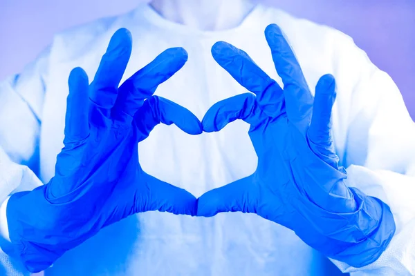Doctor or nurse shows the symbol of the heart. Love, care and safety symbol. Close-up.