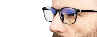 Closeup eyes of a young man in glasses isolated on white background. Banner. Place for your text. Selective focus.