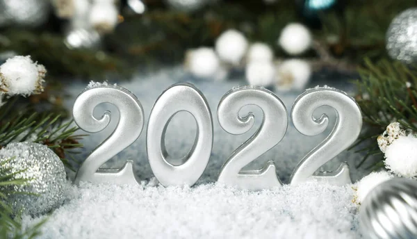 Happy New Years 2022. Christmas composition with number 2022, Christmas decorations and snow. New Year concept. Close-up.