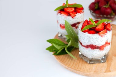 Lezzetli ve sağlıklı tatlı, taze çilek, yoğurt, chia tohumu ve taze nane. Sağlıklı kahvaltı konsepti. Yakın plan. Boşluğu kopyala.