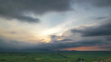 8K 7680X4320.Geniş düzlük yeşil alanlarla kaplı. Sinema büyüleyici doğa manzarası. Öğleden sonra gün batımı süresi doluyor. Tepelerle çevrili düz coğrafya..