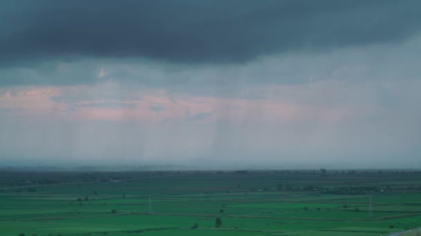 7680X4320 平野に緑のフィールドで覆われた雨 大低地の上に暗い嵐の雲 自然の中で重い降水量 タイムラプスフィールドプランテーションの背景映画的な美しい風景8K — ストック動画