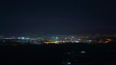 8K 7680X4320.Deniz yoluyla gece kenti. Yoğun bir kasaba sokaklarının zaman aşımı. Trafikten gelen ışık çizgileri ve parlak binalar. Parlak renkli ışıklar..