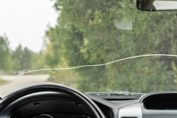 A large crack on the windshield of a vehicle in which vehicle operation is prohibited. A crack in all the glass in front of the driver and in front of the passenger