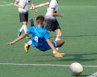 Çocuk futbolu. Maçta ve antrenmanda ilginç bir futbol anı. Çocukların futbol maçının aktif mücadelesi ve dinamiği. Çocuklar top için pervasızca savaşıyorlar..