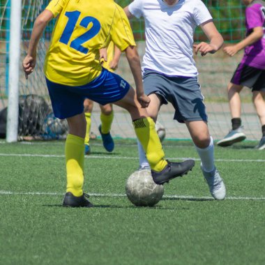 Çocuk futbolu. Maçta ve antrenmanda ilginç bir futbol anı. Çocukların futbol maçının aktif mücadelesi ve dinamiği. Çocuklar top için pervasızca savaşıyorlar..