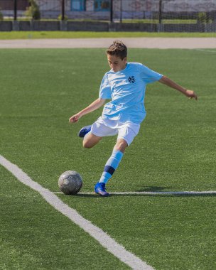 Çocuklar futbol oynuyor, genç futbolcu köşe atışı yapıyor..