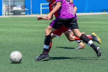Çocuk futbolu. Maçta ve antrenmanda ilginç bir futbol anı. Çocukların futbol maçının aktif mücadelesi ve dinamiği. Çocuklar top için pervasızca savaşıyorlar..