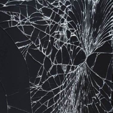 Kavram, kolaj ve maket için siyah arka planda çatlakları olan kırık bir akıllı telefon camı. Siyah üzerine beyaz gibi bardaktaki çatlakların yakın plan görüntüsü.