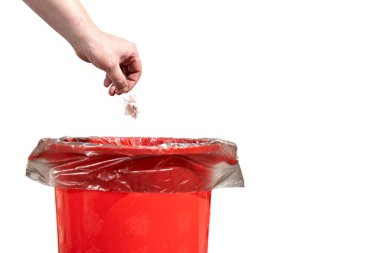 Adam kurumuş çiçeği çöp kutusuna atar. Erkek el, beyaz arka planda izole edilmiş tatilden sonra gereksiz solmuş çiçeği çöp kutusuna atar.