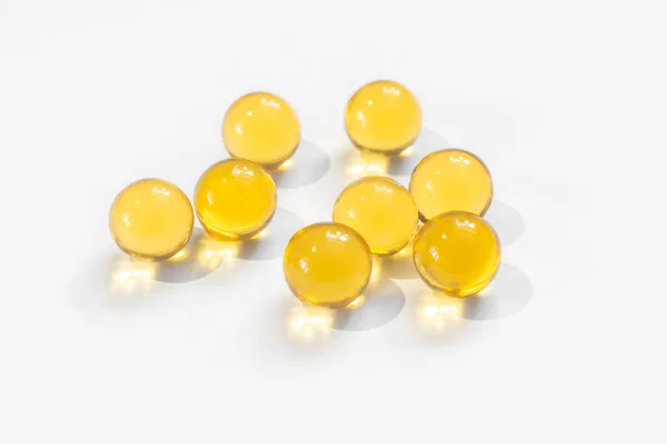 Beslenme için balık yağlı sarı yuvarlak kapsüller Omega diyet sağlığının fotokopi alanı olan beyaz arka planda yakın plan faydaları.
