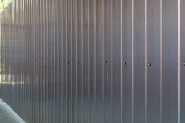 Kolajlar, reklamlar, haberler, kavramlar için ayna arka planı olarak galvanize demir gri profil kağıdından yapılmış metal çitler.