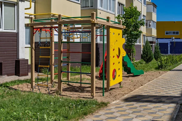 Yeşil bitkileri olan evler ve çocuklar için eğlence alanları arasında rahat bir avlu. Kozalaklar, çalılar ve çiçekler arasında açık hava eğlencesi için harika bir yer..