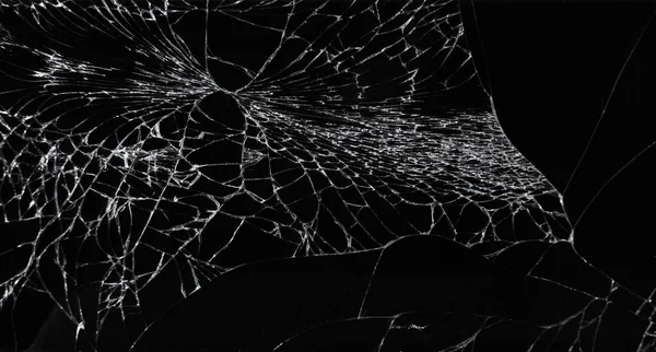 Kavram, kolaj ve maket için siyah arka planda çatlakları olan kırık bir akıllı telefon camı. Siyah üzerine beyaz gibi bardaktaki çatlakların yakın plan görüntüsü.