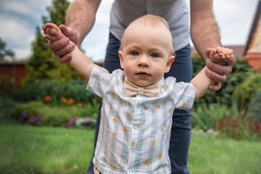Sarışın, Avrupalı bir Alman çocuk. Bir yaşında. Doğum gününde babasıyla bahçede yürüyor..