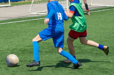 Çocuk futbolu. Maçta ve antrenmanda ilginç bir futbol anı. Çocukların futbol maçının aktif mücadelesi ve dinamiği. Çocuklar top için pervasızca savaşıyorlar..