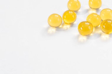 Beslenme için balık yağlı sarı yuvarlak kapsüller Omega diyet sağlığının fotokopi alanı olan beyaz arka planda yakın plan faydaları.