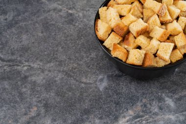 Siyah fincan plakalı vanilyalı tatlı kare krakerler. Arka planda, yakın plan çekimde. Üst görünümde fotokopi alanı..