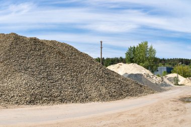 Yeni bir otoyolun inşası için kum, taş ve çakıl yığınları..