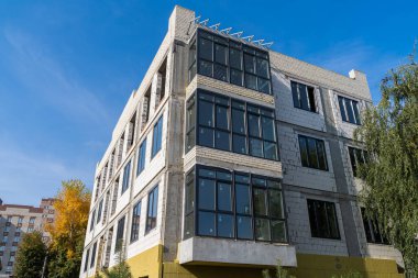 Bireysel ısıtmalı yeni bir tuğla ev yeşil bir çimenlikte çitin arkasına inşa ediliyor..