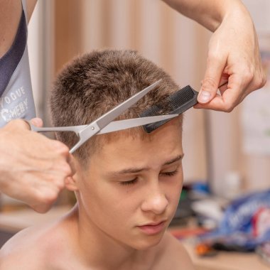 Bir çocuğun saçını kesmek, kuaföre gitmeden karantina ve koronavirüs salgını yüzünden evdeki genç adam..