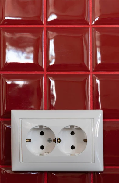 Witte Stopcontact Een Rode Keramische Tegelwand Met Geleidende Draden Stekkers — Stockfoto