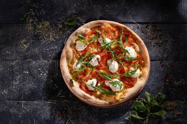 Stracciatella ve roka içeren pizza koyu ahşap arka plan görünümünde izole edilmiş.