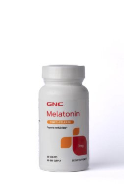 Davis, CA, 9 Temmuz 2022. Bir şişe CNC Melatonin zaman ayarlı 3 mg beyaz arka planda, merkezde, önde. Melatonin uyku problemlerinde kullanılan bir hormondur.