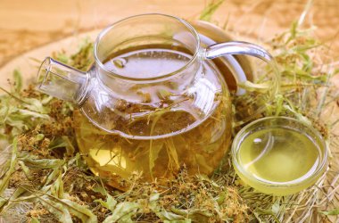 Çaydanlık şeffaf bardakta samanlıkta, ananas, nane, portakal, bal, meyve çayının yanında.