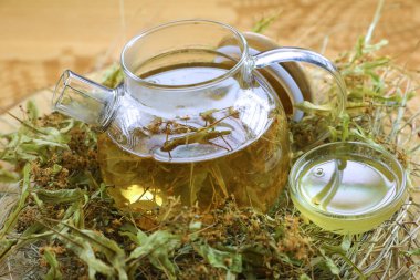 Çaydanlık şeffaf bardakta samanlıkta, ananas, nane, portakal, bal, meyve çayının yanında.