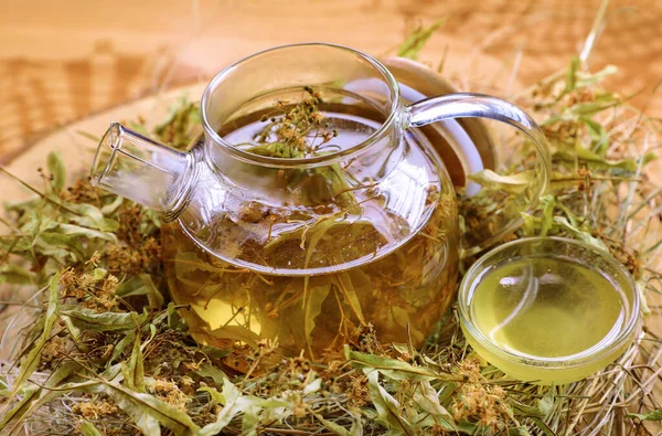 Çaydanlık şeffaf bardakta samanlıkta, ananas, nane, portakal, bal, meyve çayının yanında.