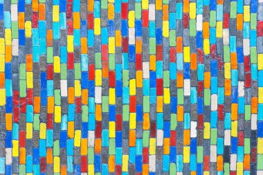 Çamur tuğla bir duvarda farklı renklerle kaplıdır. Çimento ve boyayla yeniden bağlanmış..