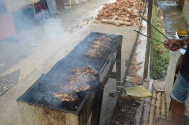 Seçici odaklanma, ızgara yapılan Tilapia balığı, muz yapraklarına sarılmış ızgara balık yemekleri..