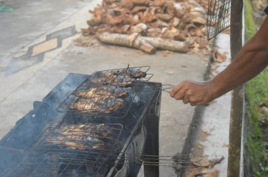 Seçici odaklanma, ızgara yapılan Tilapia balığı, muz yapraklarına sarılmış ızgara balık yemekleri..