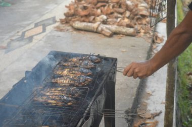 Seçici odaklanma, ızgara yapılan Tilapia balığı, muz yapraklarına sarılmış ızgara balık yemekleri..