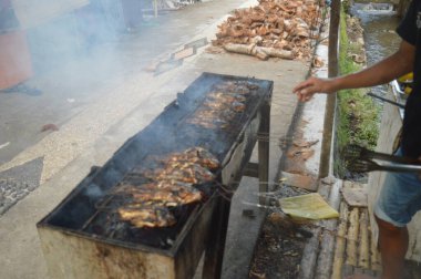 Seçici odaklanma, ızgara yapılan Tilapia balığı, muz yapraklarına sarılmış ızgara balık yemekleri..