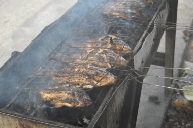 Seçici odaklanma, ızgara yapılan Tilapia balığı, muz yapraklarına sarılmış ızgara balık yemekleri..