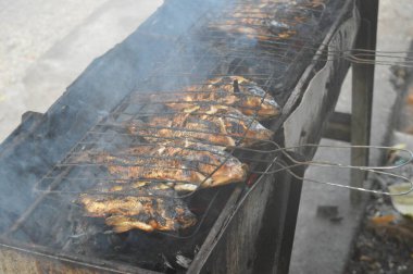 Seçici odaklanma, ızgara yapılan Tilapia balığı, muz yapraklarına sarılmış ızgara balık yemekleri..