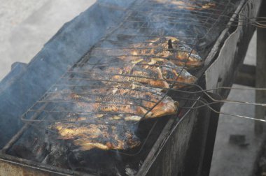 Seçici odaklanma, ızgara yapılan Tilapia balığı, muz yapraklarına sarılmış ızgara balık yemekleri..