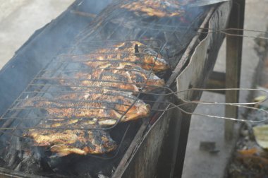 Seçici odaklanma, ızgara yapılan Tilapia balığı, muz yapraklarına sarılmış ızgara balık yemekleri..