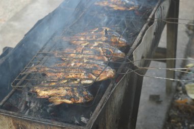 Seçici odaklanma, ızgara yapılan Tilapia balığı, muz yapraklarına sarılmış ızgara balık yemekleri..