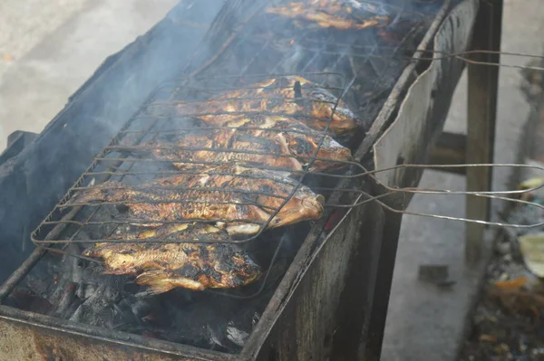 Seçici odaklanma, ızgara yapılan Tilapia balığı, muz yapraklarına sarılmış ızgara balık yemekleri..
