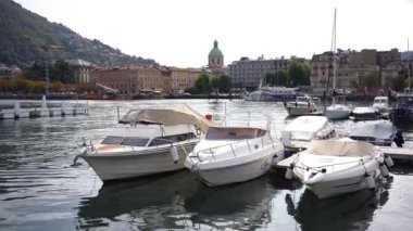 Yat ve sürat tekneleri güneşli bir günde rıhtımda Como, marina 'da rıhtıma demir attı. Yüksek kalite 4k görüntü