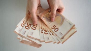 50 Euro 'luk banknotları sayan kadınların yakın çekimi. Bir iş kadını nakit sayar. Yatırım, para değişimi, rüşvet ya da yolsuzluk kavramı. Seçici odaklanma. Yüksek kalite 4k görüntü