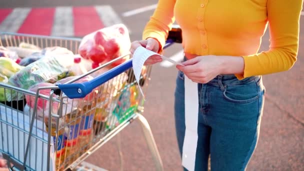 Kvinna Kontrollerar Papper Check Efter Shopping För Livsmedel Köpcentret Genom — Stockvideo