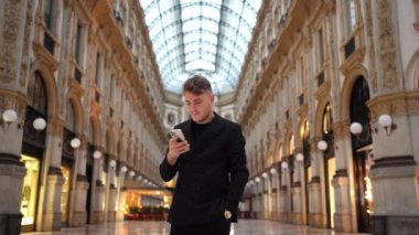 Elinde akıllı telefon tutan gülümseyen genç bir iş adamı. Cep telefonu uygulamaları kullanan orta yaşlı bir yönetici. Dijital teknoloji uygulamaları ve kurumsal gelişim için çözümler. Yüksek kalite 4k