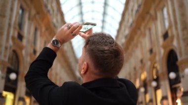 Haftasonu, erkek turistin etrafında dönerken ve dekoratif tarihi binanın cam tavanına ateş ederken düşük açılı el kamerası görüntüsü. Yüksek kalite 4k görüntü